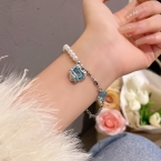 Pulsera Asimétrica Perlas y Cadena con Dije Corazón Cristal Celeste S424